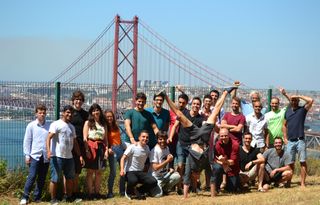 Trainees among the full PlasmaSurfers team with bridge 25 Abril behind.